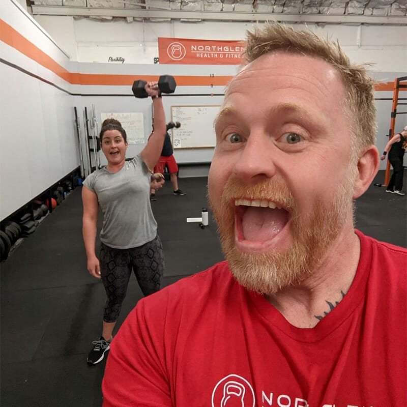 Patrick coach at Northglenn Health and Fitness with a client in the background