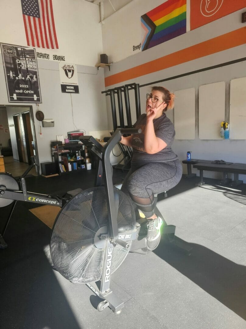 Woman on exercise bike celebrating small victories