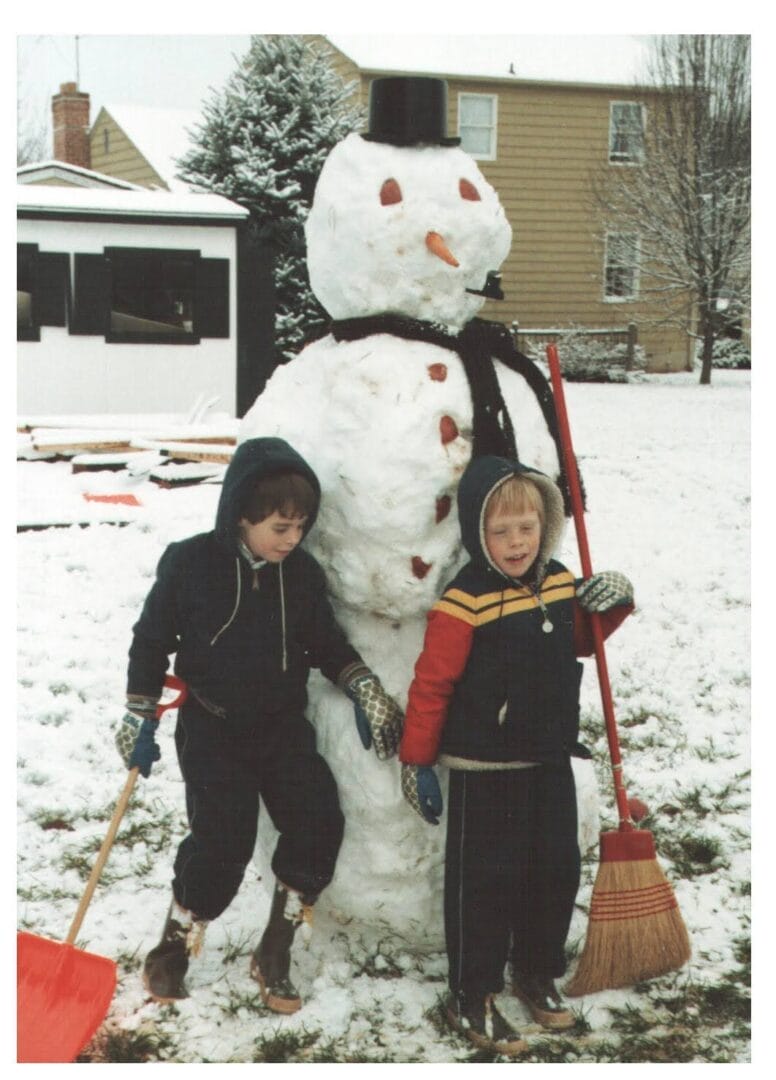 Young Coach Patrick building a snowman during a snowy Colorado day. featured in Northglenn Health and Fitness gym weather policy post